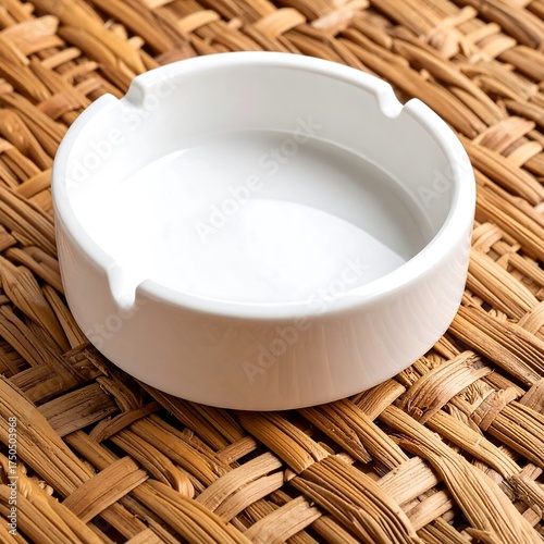 Empty white ashtray on woven placemat