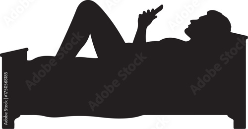 Silhouette of person lying in bed using smartphone