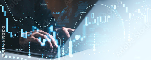 Hands typing on laptop overlaid with glowing candlestick charts and financial data, representing market analysis and crypto trading concept.