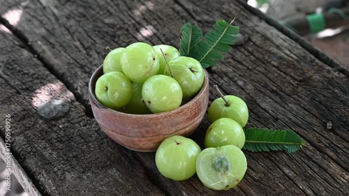 Fresh Amla (Indian gooseberry, Phyllanthus emblica) fruits with leaf on wooden background. herbal medicine plant