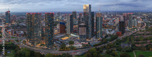 Wide panoramic aerial view of Manchester skyline and Mancunian Way traffic at twilight from Hulme Park.