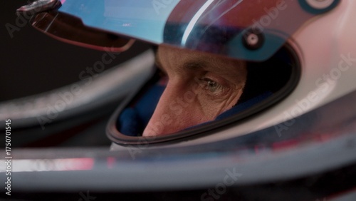 Close-up of a focused pilot driver in a red racing car preparing for a race