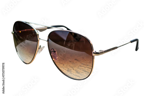 Close up view of aviator style sunglasses with brown gradient lenses on a black background outdoors