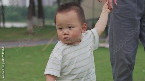 Teaching an Asian baby to walk on the grass