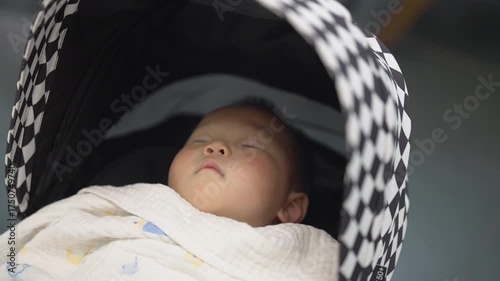 An Asian baby sleeping in a stroller
