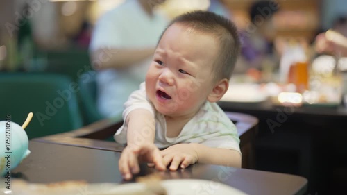 Asian baby boy throws a tantrum in restaurant after not getting the food he wanted.
