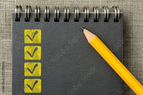 Organized checklist notebook positioned against a textured background with a yellow pencil ready for notes creating a sense of preparation and productivity in a professional setting