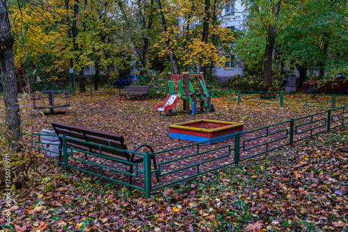 An empty playground with fallen leaves in the Moscow courtyard in autumn