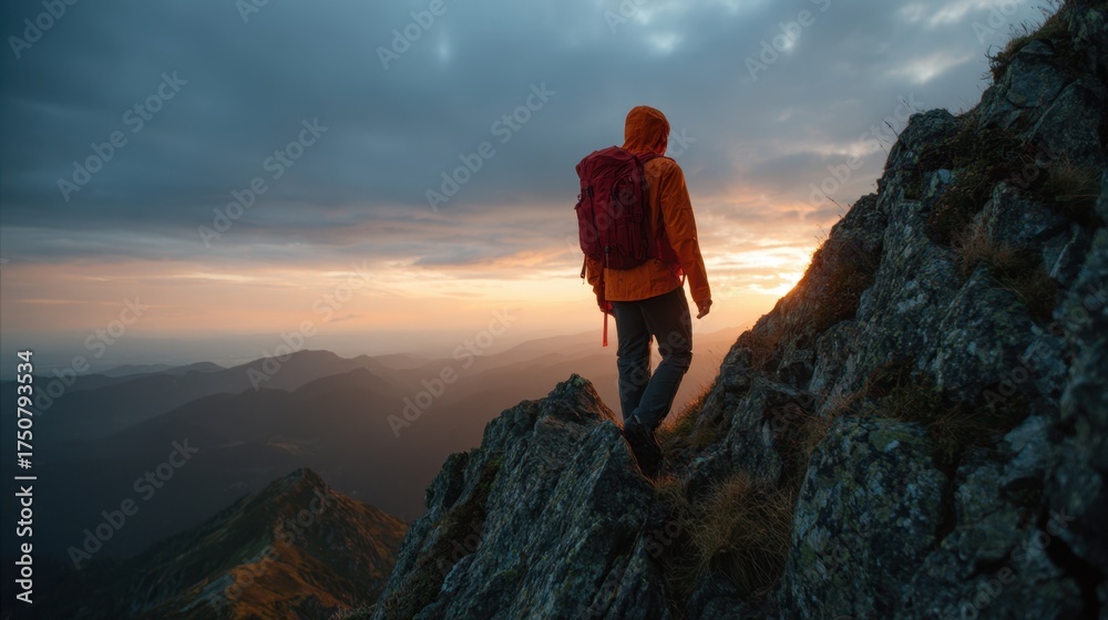 Obraz premium A hiker with a red backpack navigates rocky terrain during sunset surrounded by mountains. The sky is filled with clouds creating a stunning view of natures beauty.
