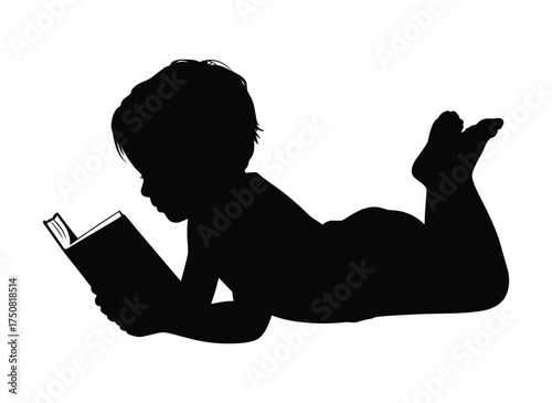 Silhouette of a young child lying down and engrossed in reading a book