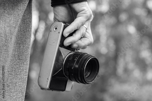 The photograph shows the hands of a person holding a camera.