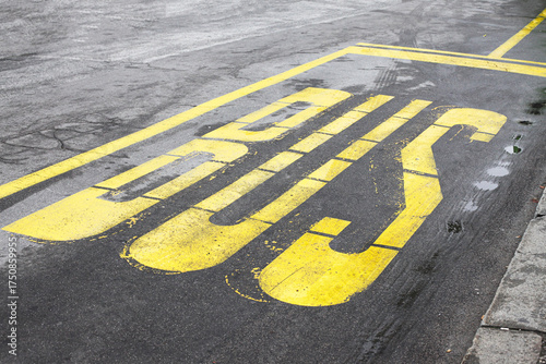 Foto Yellow bus lane marking on wet asphalt road after rain