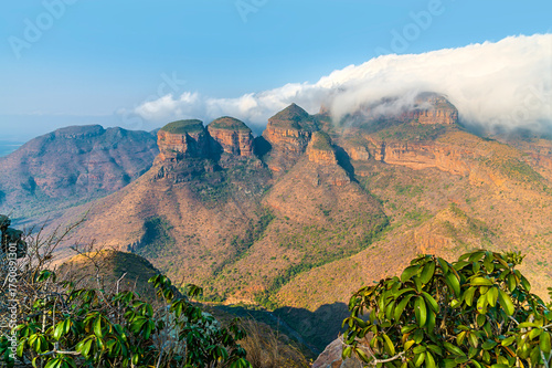 A view over bushes on the rim of Blyde River Canyon towards the three Rondavels,  Mpumalanga, South Africa in Springtime
