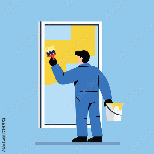 Painting wall; man in blue overalls applies yellow paint