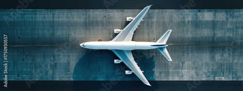 Aerial top-down view of a large white passenger airplane on the tarmac