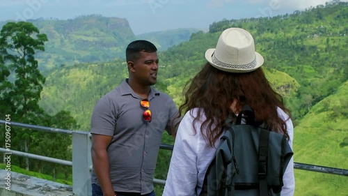Woman wearing backpack listening attentively while guide explaining scenic green hills landscape during travel adventure in lush countryside environment