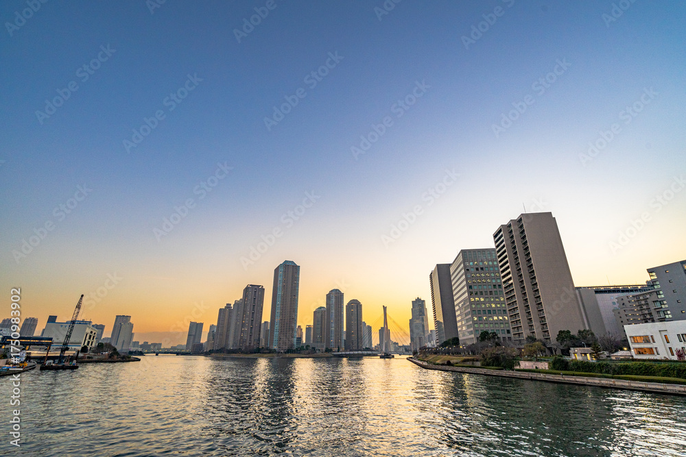 Fototapeta premium 夕焼けの中の水辺の高層マンション