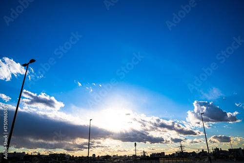 雲から光差す太陽と青空