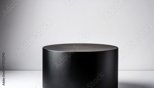 a simple black cylindrical pedestal on a minimalist white background perfect for product displays or showcasing small items