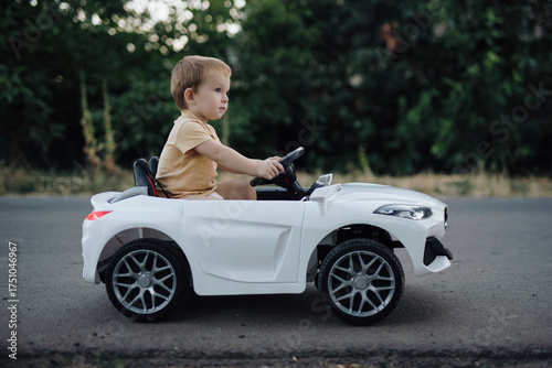 2 years boy riding electric car toy on the road
