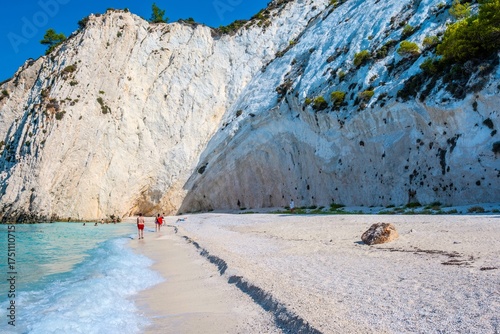 White Pebble Beach and Towering Cliffs with People Walking, White Rocks Beach in Kefalonia. Greece