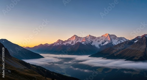 Majestic Alpine Peaks Bathed in Golden Morning Light Above Misty Valley