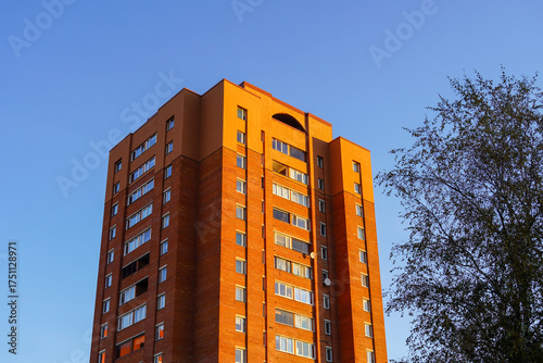 Residential building standing tall against a clear blue sky in an urban setting