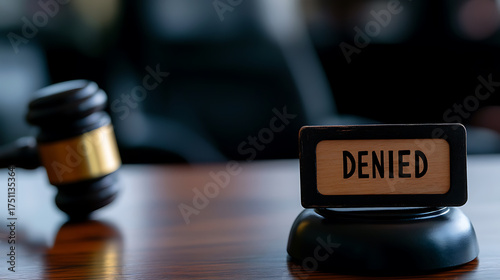 Denied: Gavel resting beside 'Denied' sign, signifying a rejected motion, verdict, or application in a legal or formal context.