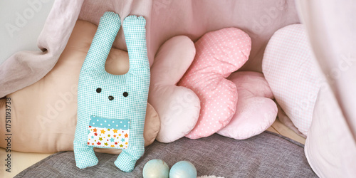 Foto Cute stuffed toys rabbit and cloud pillows in cozy nursery corner with soft pastel decor