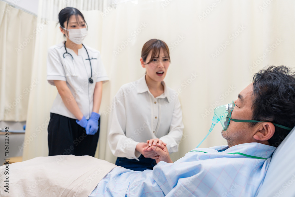 Obraz premium 人工呼吸器をつけた家族のお見舞いをする若い女性