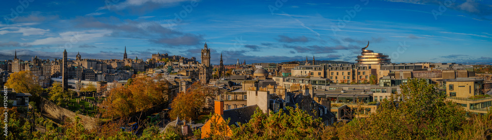 Fototapeta premium Golden hour skyline of Edinburgh, Scotland, viewed from Calton Hill, an elevated panorama of historic spires, neoclassical facades, and civic landmarks shaping the capital’s architectural legacy.