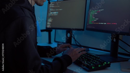Close up shot focusing on programmer’s hands typing on illuminated keyboard for software development and database coding in IT department office during night shift, showing focus and precision.