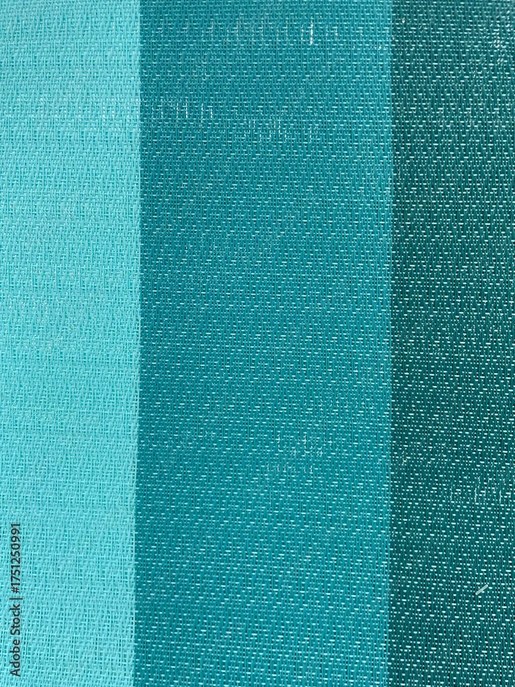 Fototapeta premium Blue and turquoise fabric texture with vertical stripes. Close-up of woven textile surface showing detailed thread pattern and smooth color gradient, background for design and decor.