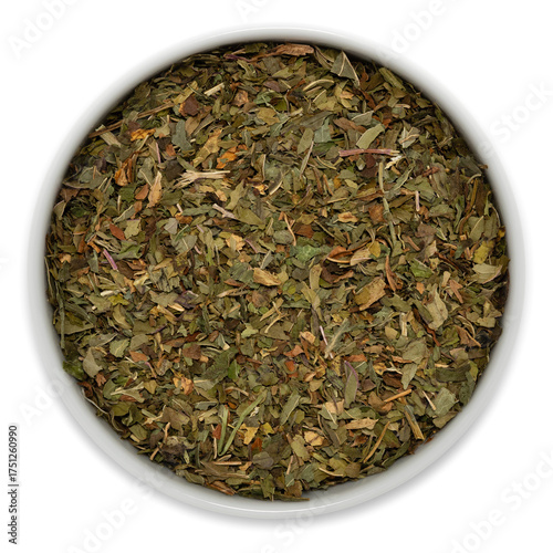 Freshly dried mint leaves in a white ceramic bowl, viewed from above, commonly used for preparing herbal tea blends
