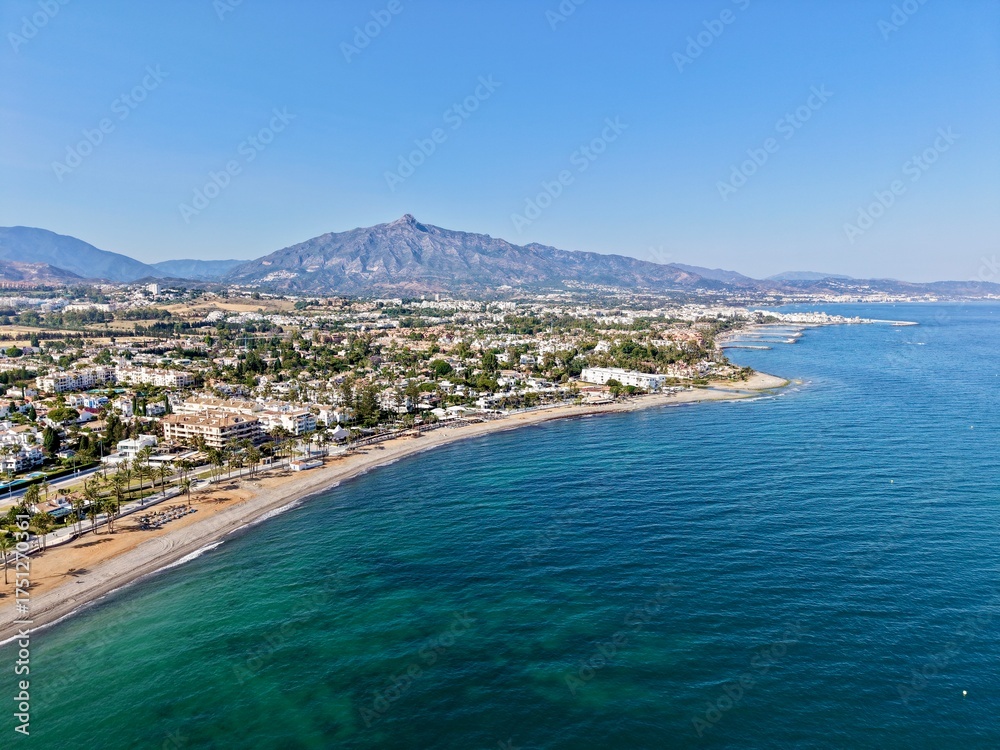 Fototapeta premium aerial view of the coast with beach and promenade with palms in San Pedro de Alcántara in beautiful light, Malaga, Costa del Sol, Andalusia, Spain 