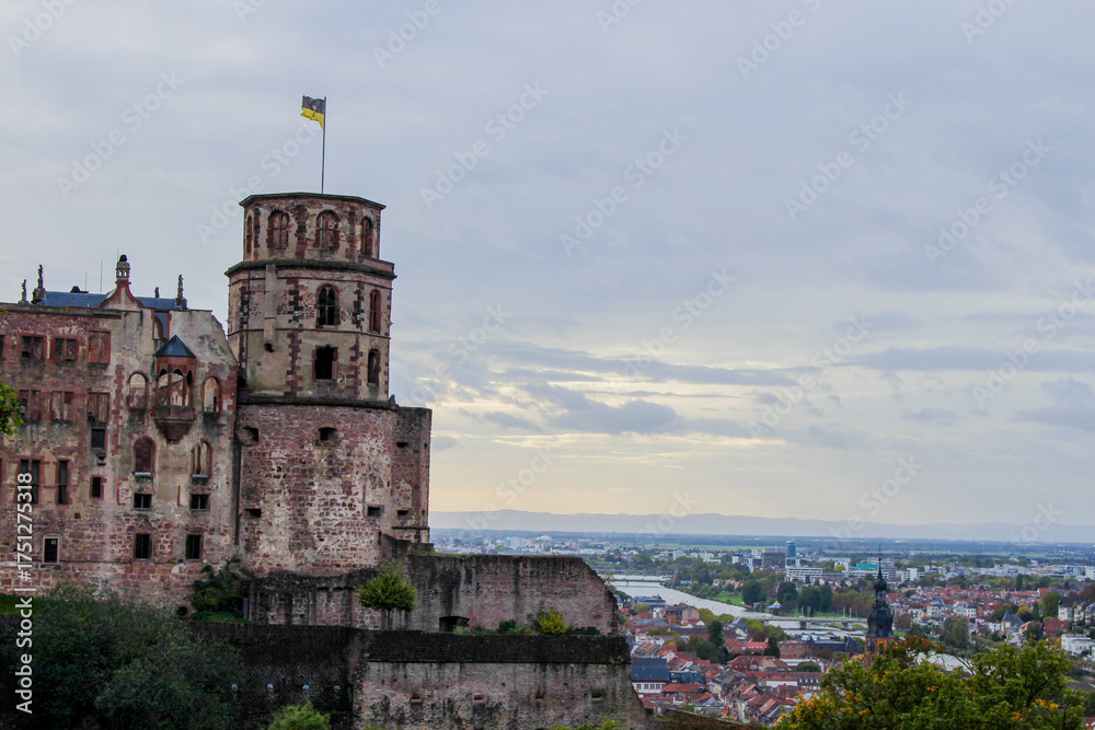 Fototapeta premium closeup of the heidelberg castle tower and a wide panoramic view of the landscape with the city, river and mountains in the back