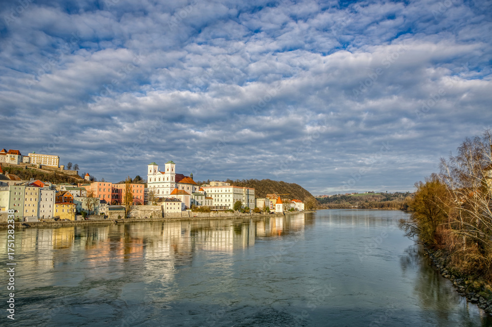 Fototapeta premium Panoramic view of Passau Bavaria Germany with historic riverside buildings and fortress under cloudy sky