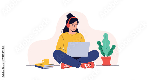 A person working on a laptop while wearing headphones and sitting next to a plant.