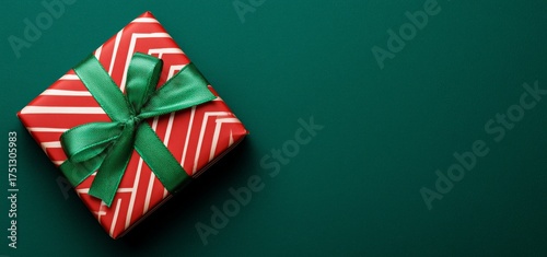 Colorful Gift Box With Red and White Wrapping on Green Background During Holi...