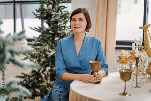 Woman Holding a Golden Chalice by Festive Table
