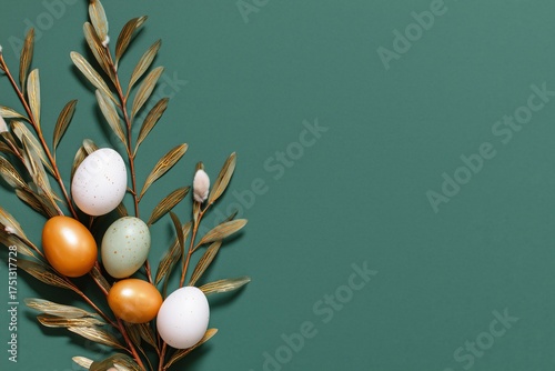 Colorful Easter Eggs Arranged With Willow Branches on a Green Background