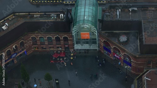 Drone footage of Liverpool city under light rain on an autumn day. Buses and cars move through wet roads, reflecting soft light. A melancholic yet peaceful mood, ideal for creative projects, branding 