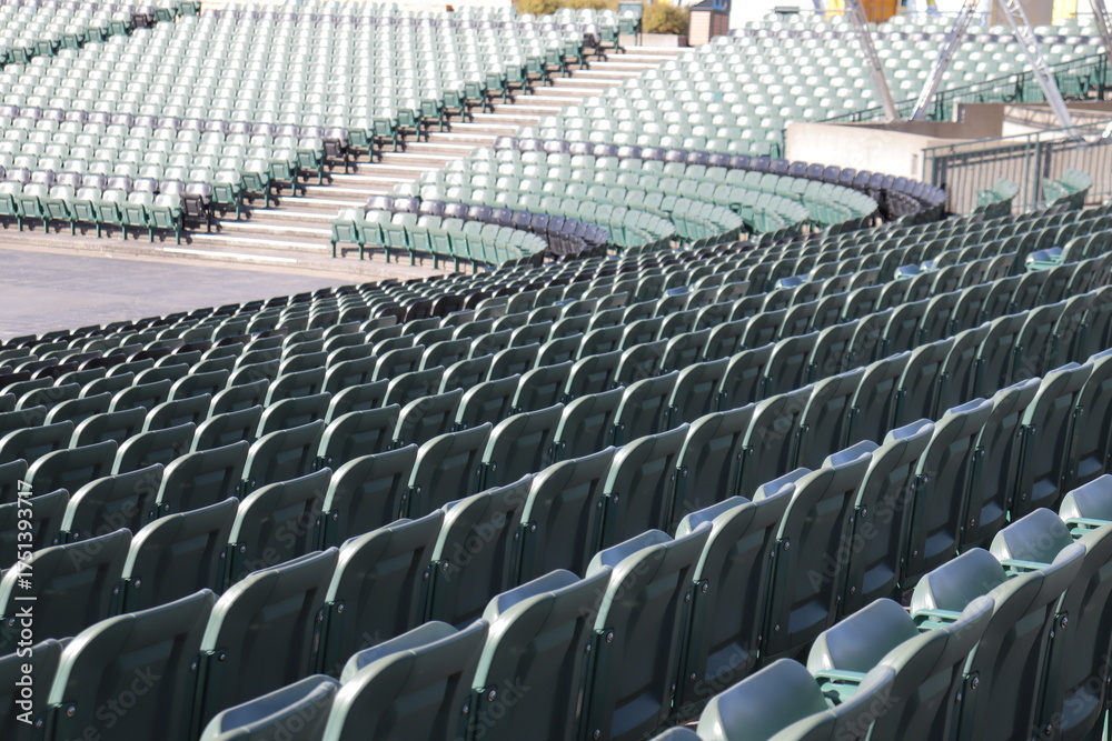 Naklejka premium Rows of seats in stadium and outdoor event in summer. Outdoor architecture and exterior amphitheater with green seats. Seats design and public stadium. Outdoor show in summer.
