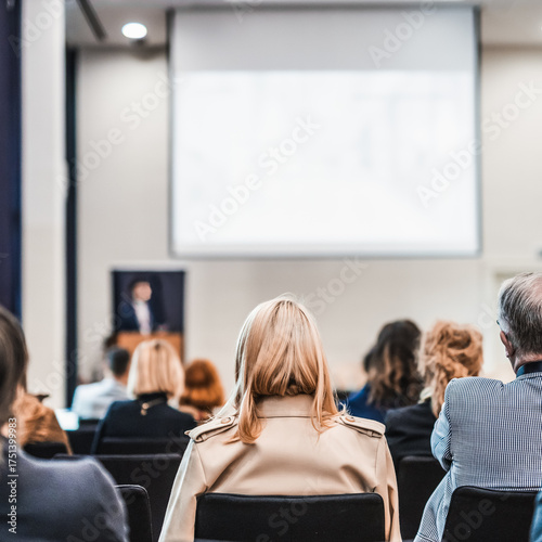 Speaker giving a talk in conference hall at business event. Rear view of unrecognizable people in audience at the conference hall. Business and entrepreneurship concept