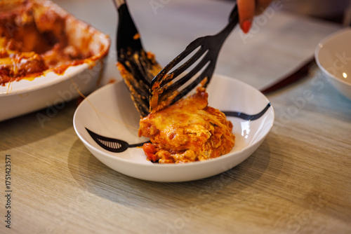 Serving delicious homemade lasagna onto a plate for a comforting meal at home