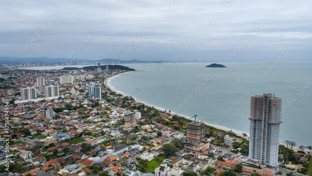 Fototapeta premium Cityscape of Penha, Santa Catarina, Brazil, showing its coastal skyline along the Atlantic Ocean under a cloudy sky.
