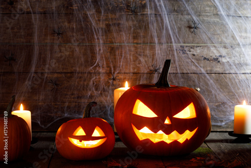 Halloween pumpkins with faces in a barn on a wooden background