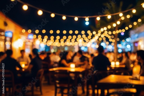 屋外レストランやバーの夜景：ストリングライトと賑わう群衆のぼかし