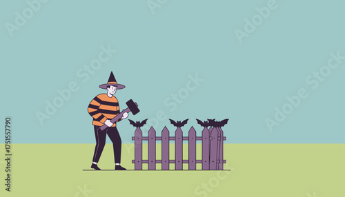 Person in witch hat decorating a fence with bats for Halloween using a mallet