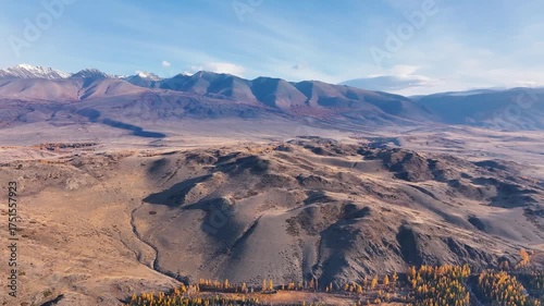 Experience the stunning beauty of Altai mountains during autumn as vibrant colors fill the valleys. The aerial view captures the vast wilderness and serene landscapes, inviting exploration.
